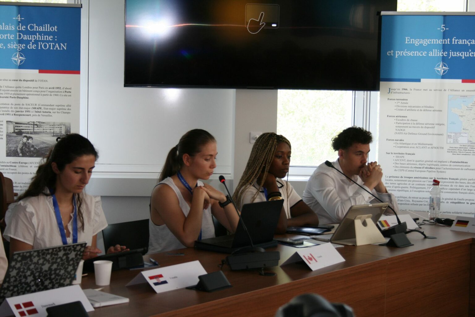Young delegates at work behind their national name plates during the “NATO in Action” exercise