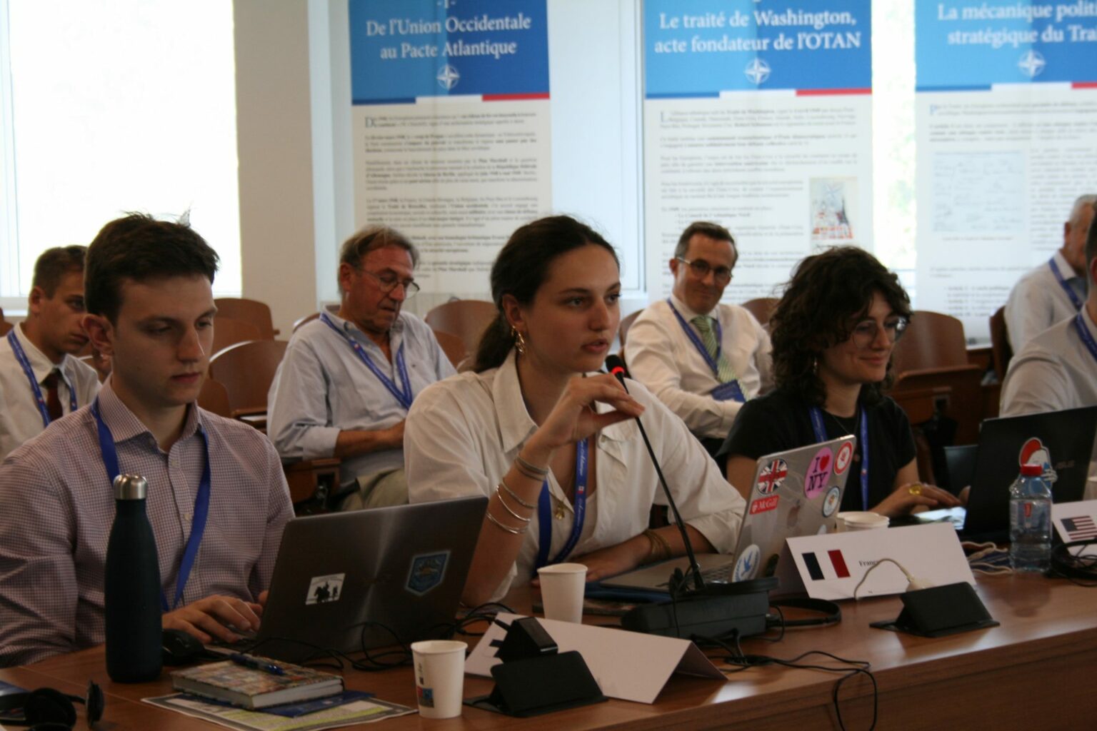 A delegate speaks at the microphone during the simulated North Atlantic Council session